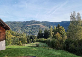 Vista dal chalet 'Ronds Chetys' in Francia con colline verdi, boschi e montagne sullo sfondo.