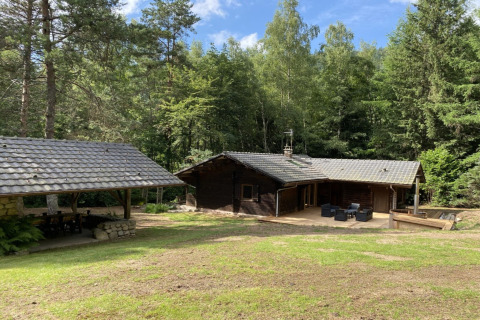 Afbeelding van LE FISHING LODGE, houten chalet met terras en bosrijke omgeving in Frankrijk.