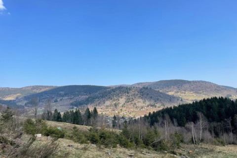 Vista panoramica dal chalet 'Ronds Chetys' in Francia con colline, foreste e cielo azzurro limpido.
