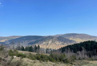 Vista panoramica dal chalet 'Ronds Chetys' in Francia con colline, foreste e cielo azzurro limpido.
