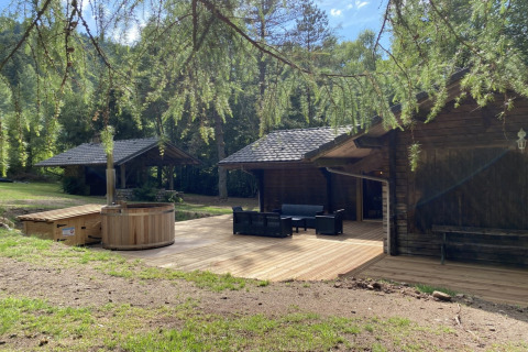 LE FISHING LODGE: Houten chalet met Scandinavisch bad, terras en bos in Frankrijk, ontspannen sfeer.