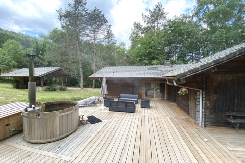 Vista dello chalet in legno LE FISHING LODGE con bagno nordico e ampia terrazza in Francia.