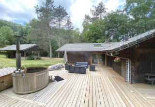 Vista dello chalet in legno LE FISHING LODGE con bagno nordico e ampia terrazza in Francia.