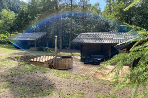 LE FISHING LODGE houten chalet met Noors bad in Frankrijk, omgeven door bomen en natuur.