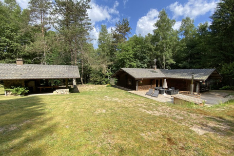 LE FISHING LODGE houten chalet in Frankrijk, omringd door bos, terras en een nordic bad buiten.