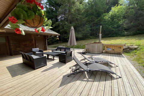 Terrazza esterna dello chalet LE FISHING LODGE in Francia con mobili lounge e bagno nordico.