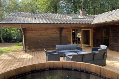 Houten terras van het LE FISHING LODGE chalet in Frankrijk met Scandinavisch bad en tuinset.