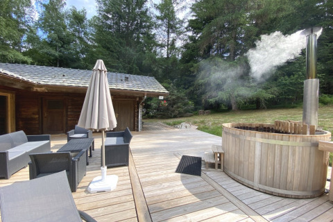 Outdoor deck at LE FISHING LODGE, France, featuring lounge seating and a steaming Nordic bath.