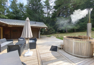 Outdoor deck at LE FISHING LODGE, France, featuring lounge seating and a steaming Nordic bath.