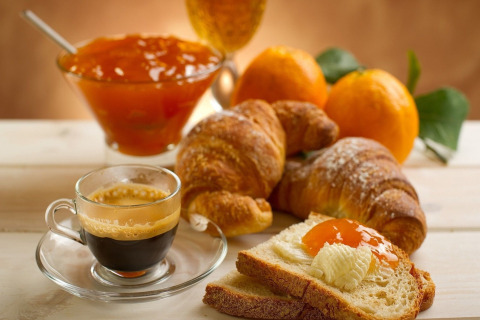 Frans ontbijt met espresso, croissants en sinaasappeljam in het chalet LE FISHING LODGE in Frankrijk.