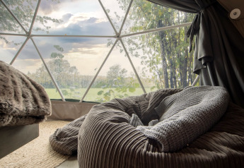 Gezellig interieur van Chartwell Luxury Dome met uitzicht op groene velden in het prachtige Verenigd Koninkrijk.