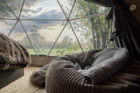 Cozy interior of Chartwell Luxury Dome with a view of green fields in the beautiful United Kingdom.