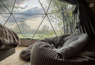 Cozy interior of Chartwell Luxury Dome with a view of green fields in the beautiful United Kingdom.