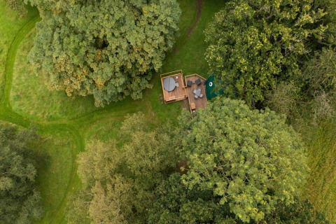 Luchtfoto van Chartwell Luxury Dome in het Verenigd Koninkrijk, omgeven door groene bomen en gras.