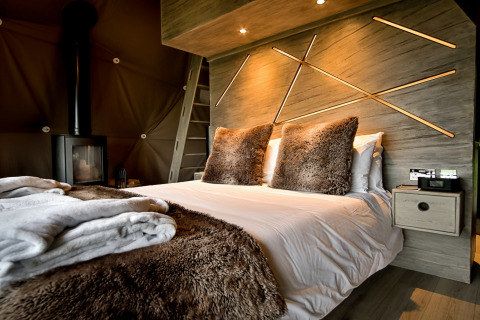 Moderne soveværelse i Hever Luxury Dome, Storbritannien, med plysset sengetæppe og dekorativ væg.