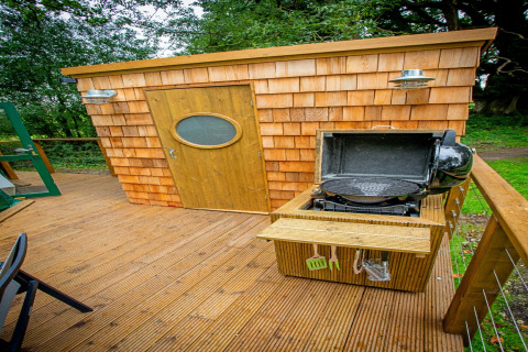 Træterrasse med grill og skur foran Hever Luxury Dome, naturrigdom i Storbritannien omkring området.