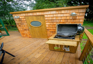 Træterrasse med grill og skur foran Hever Luxury Dome, naturrigdom i Storbritannien omkring området.