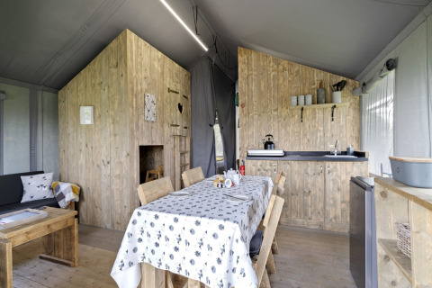 Interieur van de Herdwick Safari Tent in het VK met eettafel, kitchenette en zithoek.