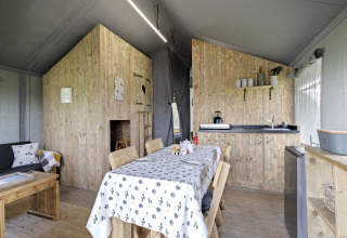Interieur van de Herdwick Safari Tent in het VK met eettafel, kitchenette en zithoek.