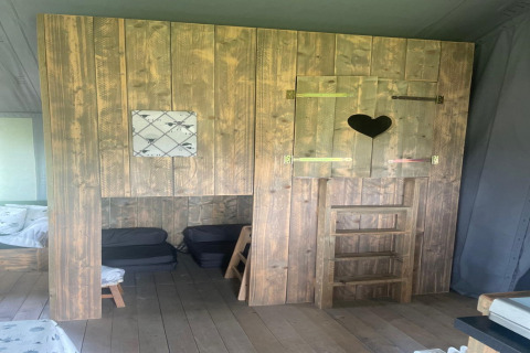 Houten interieur in The Herdwick Safari Tent met hartvormig raam en kleine ladder in het Verenigd Koninkrijk.