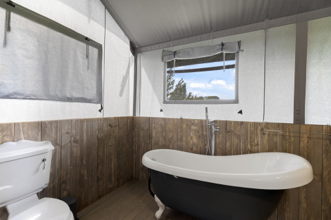 Badkamer in de Herdwick Safari Tent in het Verenigd Koninkrijk met vrijstaand bad en toilet.