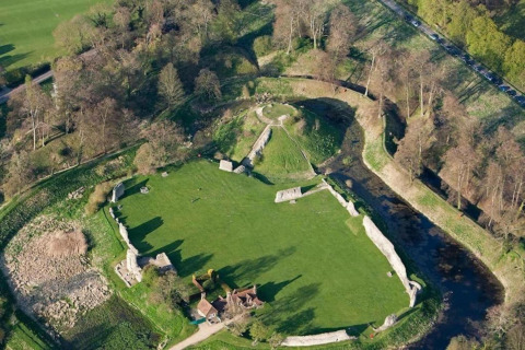 Luchtfoto van The Herdwick Safari Tent in het Verenigd Koninkrijk, met grasvelden en kasteelruïnes tussen bomen.