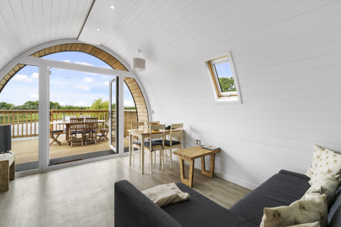 Interieur van The Highland Camping Pod in het VK met glazen deuren naar terras en uitzicht op het platteland.