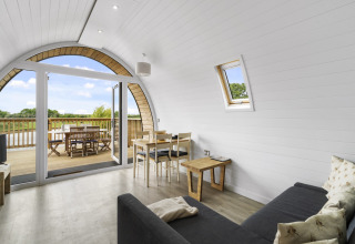 Interieur van The Highland Camping Pod in het VK met glazen deuren naar terras en uitzicht op het platteland.