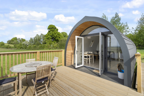 Houten terras met tuinmeubilair bij een moderne Highland Camping Pod in het Verenigd Koninkrijk.