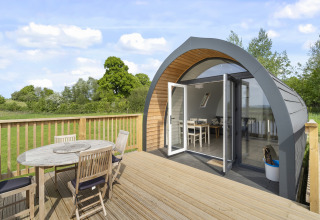 Houten terras met tuinmeubilair bij een moderne Highland Camping Pod in het Verenigd Koninkrijk.