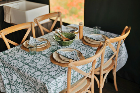 Gedekte eettafel in een safaritent met houten stoelen, patroon tafelkleed en stijlvol servies in het Verenigd Koninkrijk.