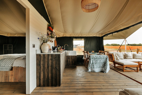 Interieur van een luxe safaritent met slaapkamer, keuken en eetgedeelte bij Owls Nest in het Verenigd Koninkrijk.