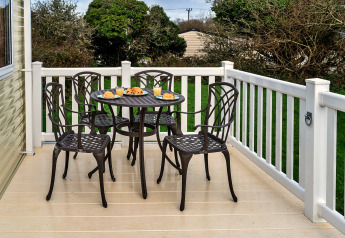 Ein Terrassentisch mit vier Stühlen und Frühstück, aufgenommen im Phoenix Retreat im Vereinigten Königreich.