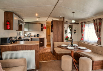 Moderne Chalet-Küche und Essbereich mit Holzakzenten, Eckbank und gedecktem Tisch, Phoenix Retreat UK.