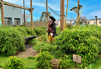 Minigolfbahn beim Phoenix Retreat im Vereinigten Königreich mit Piratenfigur, Kanone und viel Grün.