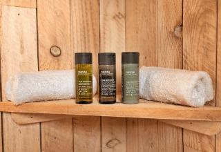 Wooden shelf with two rolled towels and three spa amenity bottles in Ashdown Luxury Dome, United Kingdom.