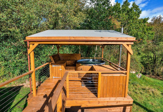 Overdekt houten terras met hot tub in de natuur bij Wakehurst Luxury Dome, Verenigd Koninkrijk.