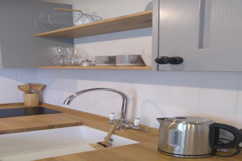Moderne keuken in de stacaravan 'The Bakers Hut' in het Verenigd Koninkrijk met waterkoker en houten aanrecht.