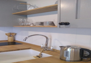 Moderne keuken in de stacaravan 'The Bakers Hut' in het Verenigd Koninkrijk met waterkoker en houten aanrecht.