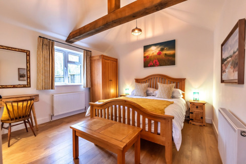 Camera accogliente al South Downs Lodge con arredi in legno, letto matrimoniale e luce naturale.
