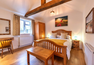 Camera accogliente al South Downs Lodge con arredi in legno, letto matrimoniale e luce naturale.