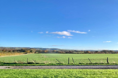 Vista su campi verdi e cielo azzurro dal mobilhome South Downs Lodge nel Regno Unito.