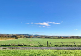 Vista su campi verdi e cielo azzurro dal mobilhome South Downs Lodge nel Regno Unito.