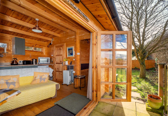 Gezellige lodge Pottles Retreat in het Verenigd Koninkrijk met open deuren en uitzicht op tuin.