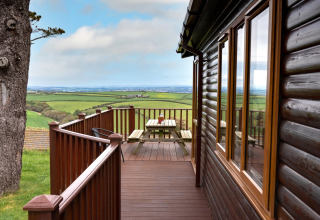 Uitzicht vanaf het terras bij Whitsand Bay Lodge in het Verenigd Koninkrijk, met picknicktafel en groene velden.
