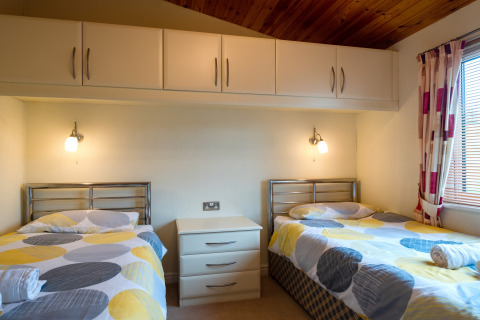 Tweepersoonskamer met vrolijk beddengoed in Whitsand Bay Lodge, Verenigd Koninkrijk, modern en knus.