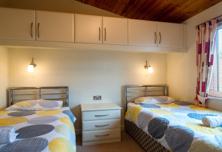 Tweepersoonskamer met vrolijk beddengoed in Whitsand Bay Lodge, Verenigd Koninkrijk, modern en knus.