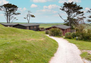 Grindpad naar Whitsand Bay Lodge in het VK, omringd door groene heuvels, bomen en velden.