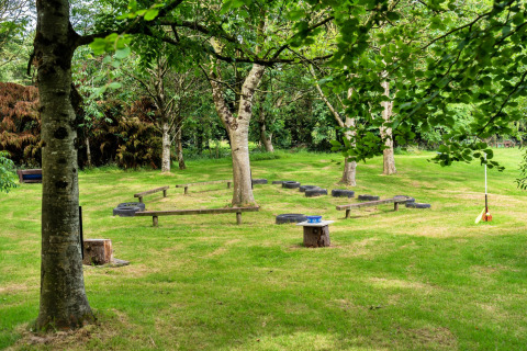 Area verde all'aperto con alberi, pneumatici e panche vicino a Oak Lotus Belle Tent, nel Regno Unito.