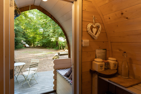 Uitzicht vanuit de Daisy Glamping Pod in het VK, met houten interieur en knusse zitplek buiten.